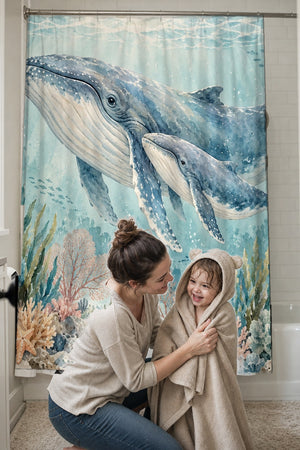 Mom drying her toddler in a hooded towel in front of the Whale Family Ocean shower curtain