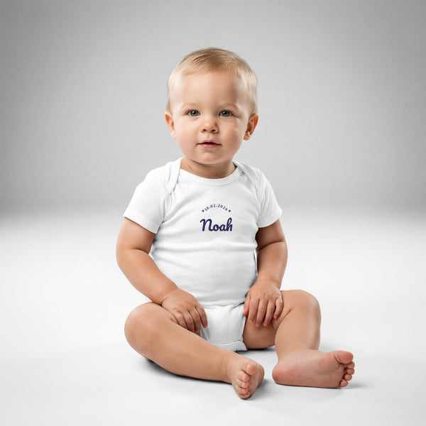 Baby boy wearing the embroidered Noah name and birth date bodysuit