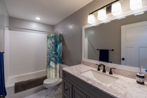 Treasure Cove Ocean shower curtain pulled open in a gray kids bathroom