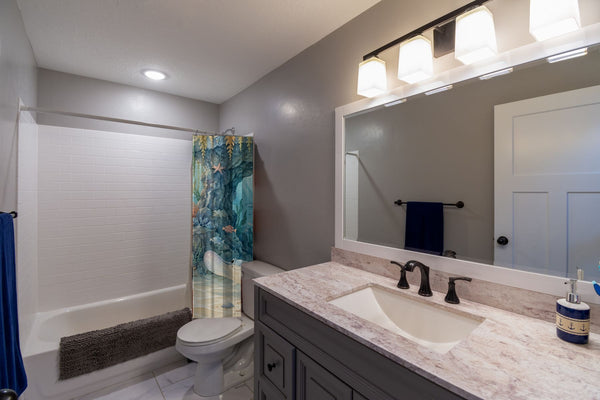 Treasure Cove Ocean shower curtain pulled open in a gray kids bathroom