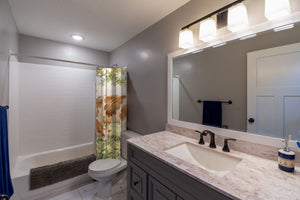 Cow and Calf Farm shower curtain pulled open in a gray kids bathroom
