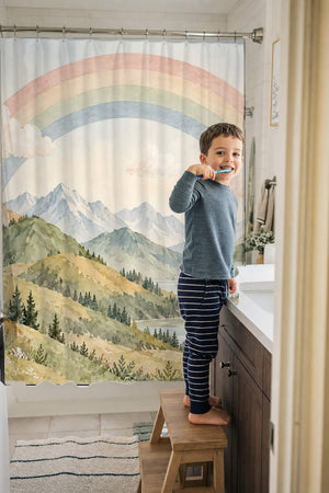 Child brushing teeth in a family bathroom with the Golden Valley Rainbow shower curtain