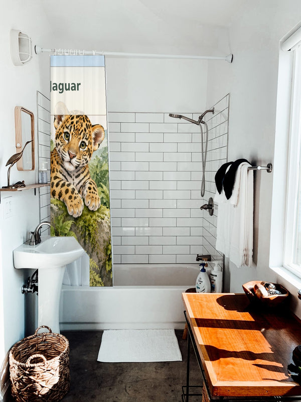 J is for Jaguar Alphabet shower curtain hanging on the rod over a white bathtub
