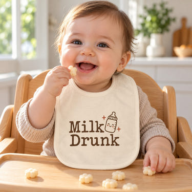 Milk Drunk baby bib in cream, styled photo 1