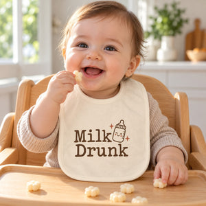 Milk Drunk baby bib in cream, styled photo 1