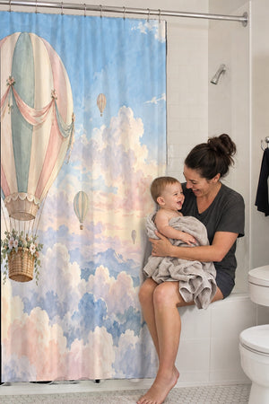 Mom holding her baby on the tub edge next to the Dreamy Clouds Hot Air Balloon shower curtain