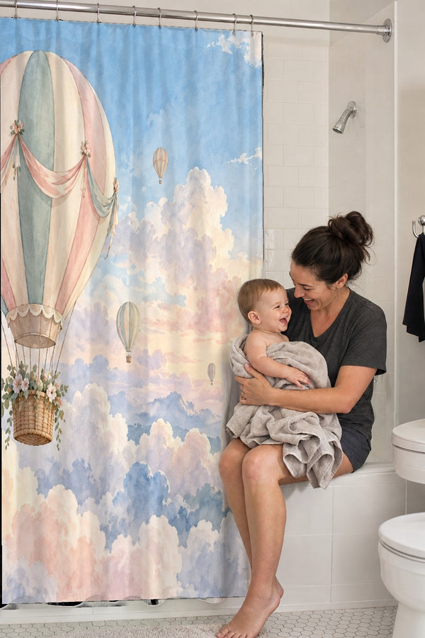 Mom holding her baby on the tub edge next to the Dreamy Clouds Hot Air Balloon shower curtain