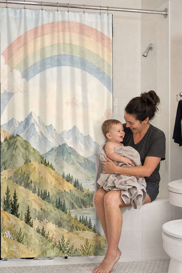Mom holding her baby on the tub edge next to the Golden Valley Rainbow shower curtain