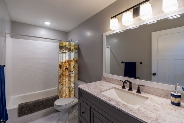 Lion Cub Safari shower curtain pulled open in a gray kids bathroom