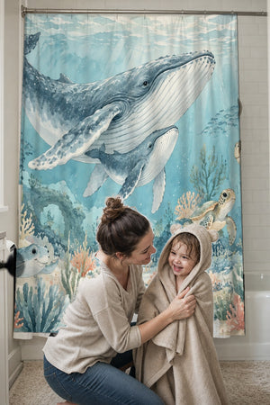 Mom drying her toddler in a hooded towel in front of the Ocean Kingdom shower curtain