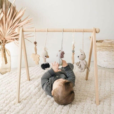 Colorful baby activity gym with crochet toys for playtime and development.