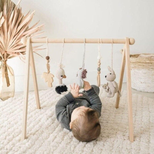 Colorful baby activity gym with crochet toys for playtime and development.