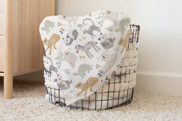Vintage baby blanket featuring pastel-colored baby animals, perfect for cozying up your little one.
