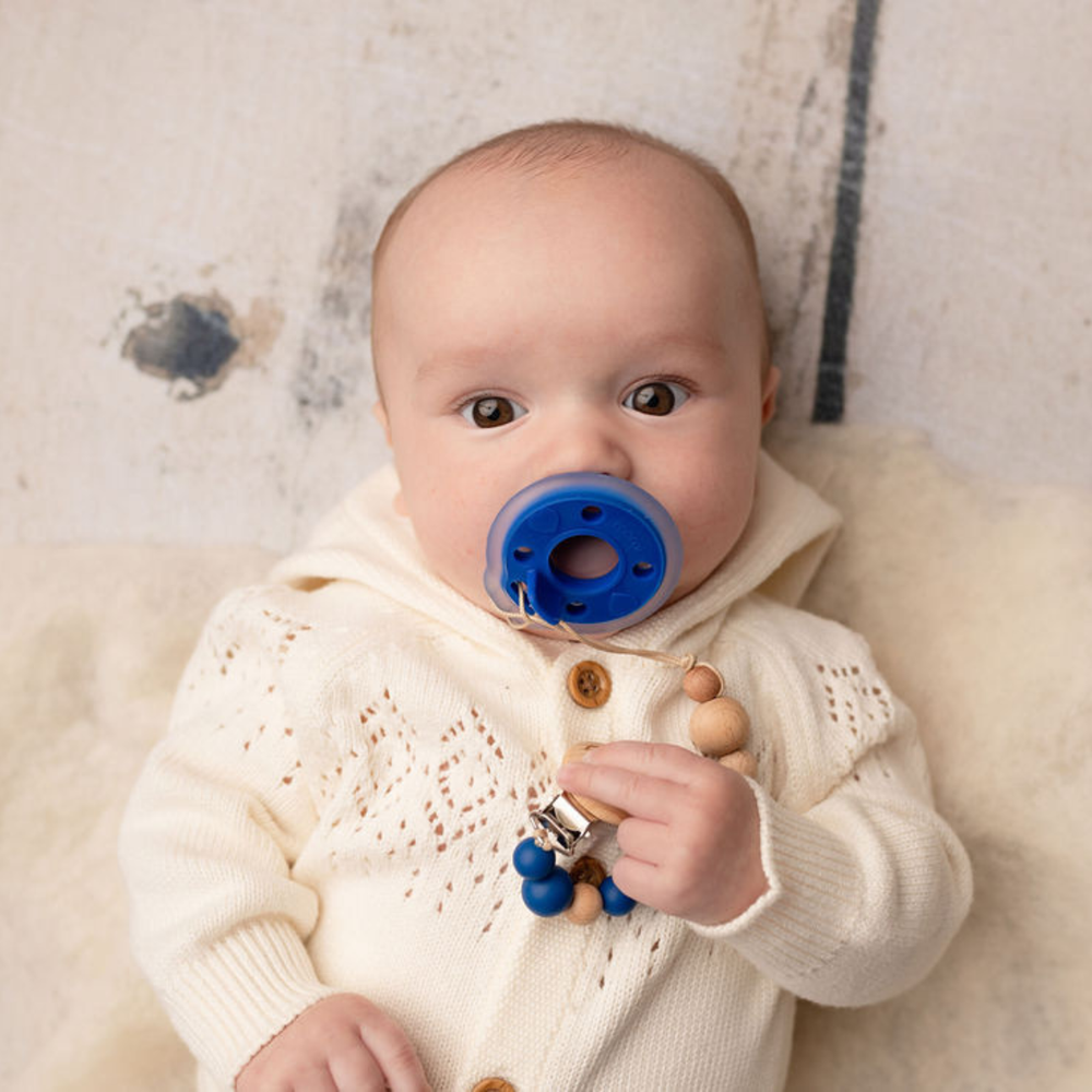 Deep lapis blue mōmi babypace® breast-like pacifier for infants, designed for comfort and soothing.