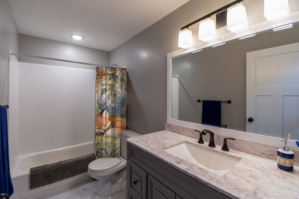 Sleepy Fox shower curtain pulled open in a gray kids bathroom