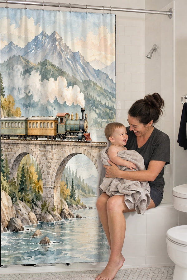 Mom holding her baby on the tub edge next to the Mountain Bridge Train shower curtain