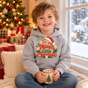 Child wearing the Mama's Little Snowflake toddler hoodie at Christmas