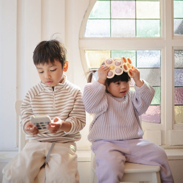 Colorful flower press toy for babies, promoting creativity and fine motor skills. Angle view showcasing vibrant design.