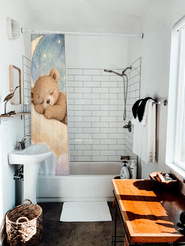 Moon Bear shower curtain hanging on the rod over a white bathtub