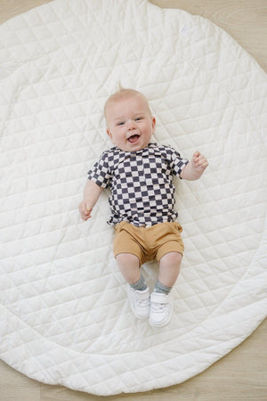 Black checkered bamboo tee for babies, stylish and comfortable, displayed at an angle. Perfect for casual wear.