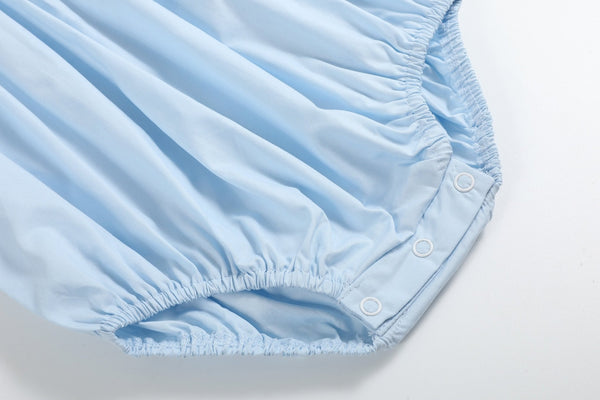 Blue and pink bow smocked romper for babies, showcasing a stylish design from an angled view.