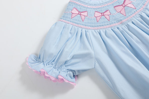 Blue and pink bow smocked romper for babies, perfect for stylish and comfortable playtime.