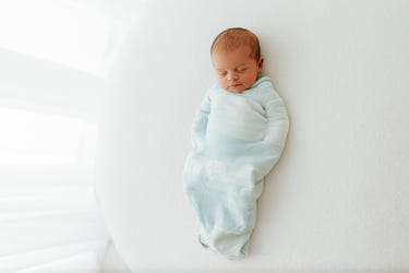 Blue Swaddle Sleep Sack from Swaddelini, perfect for keeping your baby cozy and secure during sleep.