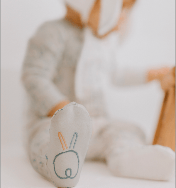 Cute baby footie with bunnies design, perfect one-piece outfit for little ones, shown from angle 8.