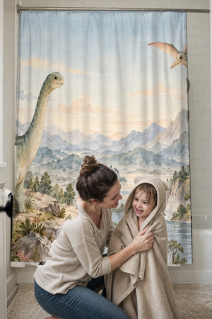 Mom drying her toddler in a hooded towel in front of the Mountain Dinosaur shower curtain