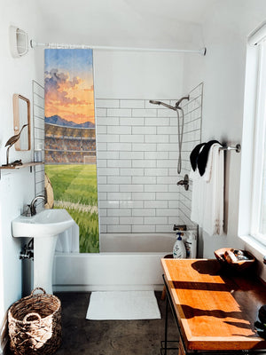 Stadium Sunset Soccer shower curtain hanging on the rod over a white bathtub