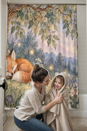 Mom drying her toddler in a hooded towel in front of the Sleepy Fox shower curtain