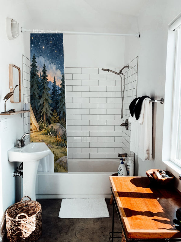 Starry Tent Camping shower curtain hanging on the rod over a white bathtub