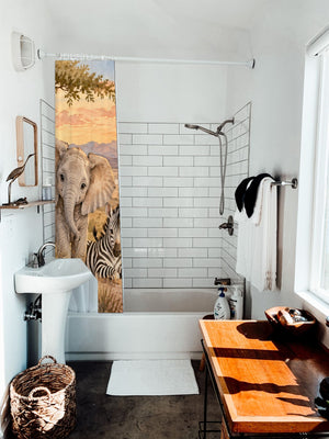 Sunset Savanna shower curtain hanging on the rod over a white bathtub