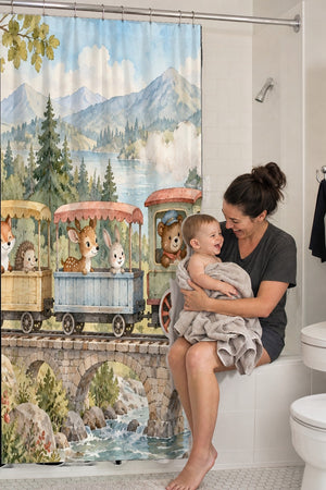 Mom holding her baby on the tub edge next to the Animal Train shower curtain