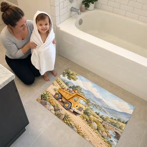 Toddler in a hooded towel stepping onto the Dump Truck Road bath mat
