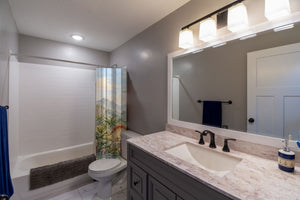 Tropical Dinosaur Garden shower curtain pulled open in a gray kids bathroom