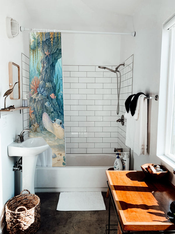 Treasure Cove Ocean shower curtain hanging on the rod over a white bathtub