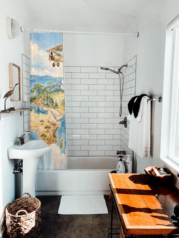 World Explorer shower curtain hanging on the rod over a white bathtub