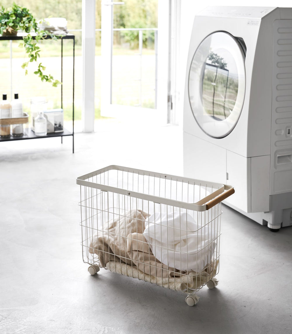 Rolling wire laundry basket with steel and wood design, 15" H, perfect for organizing baby essentials.