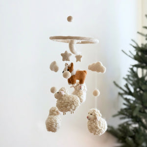 Close-up detail of needle-felted wool texture on the corgi and sheep baby mobile pieces