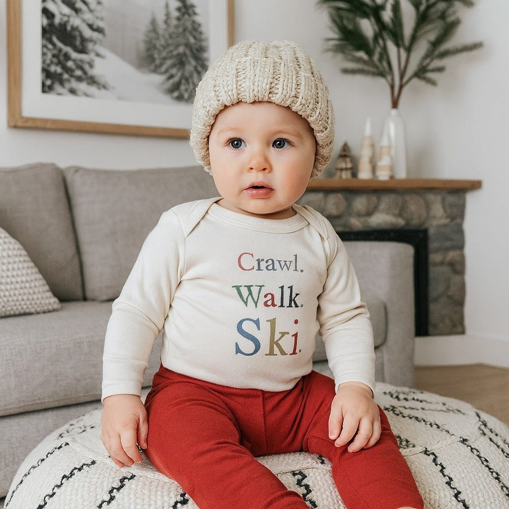 Long sleeve graphic bodysuit for babies featuring "crawl walk ski" design, perfect for playful outfits.