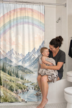 Mom holding her baby on the tub edge next to the Mountain River Rainbow shower curtain