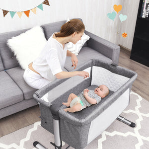 Portable baby bed side sleeper bassinet crib with carrying bag for travel convenience and comfort.