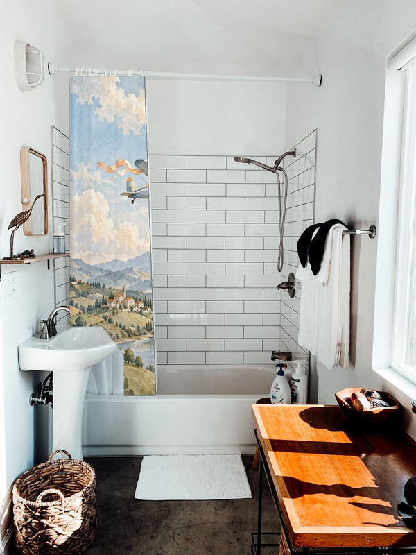 Balloon and Plane shower curtain hanging on the rod over a white bathtub