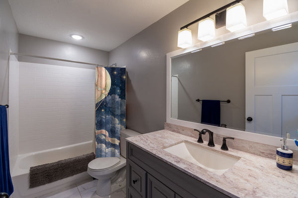 Moonlit Flight Hot Air Balloon shower curtain pulled open in a gray kids bathroom