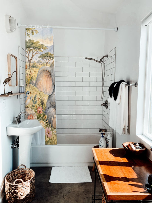 Elephant Drum shower curtain hanging on the rod over a white bathtub