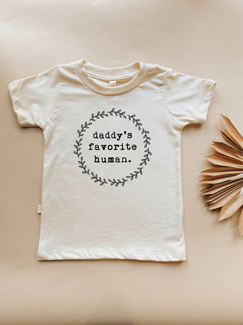 Organic kids t-shirt featuring "Daddy’s Favorite Human" design, angle view showcasing soft fabric and vibrant print.