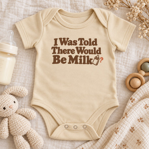 Styled flat lay of the I Was Told There Would Be Milk baby bodysuit