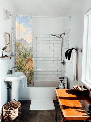 Tropical Dinosaur Garden shower curtain hanging on the rod over a white bathtub