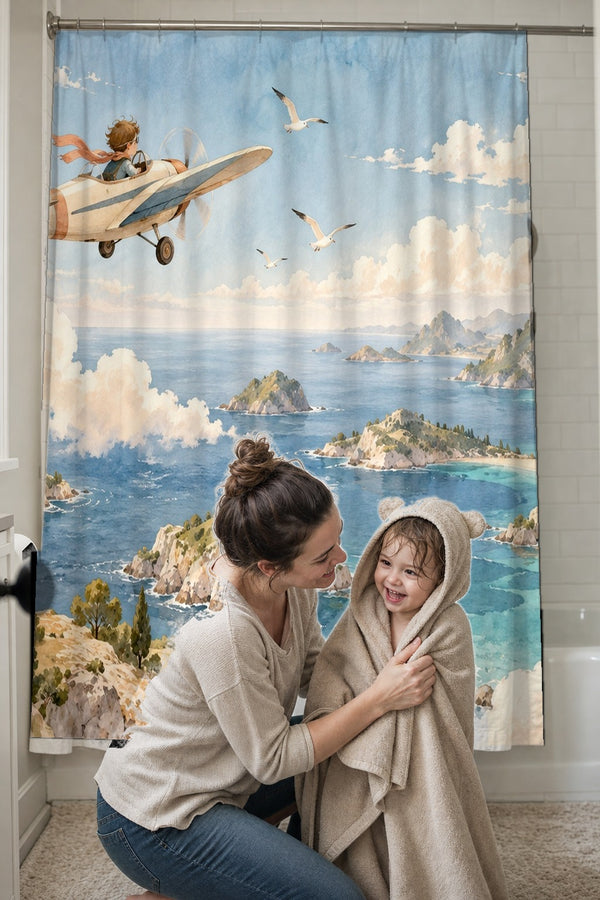 Mom drying her toddler in a hooded towel in front of the Coastal Explorer shower curtain